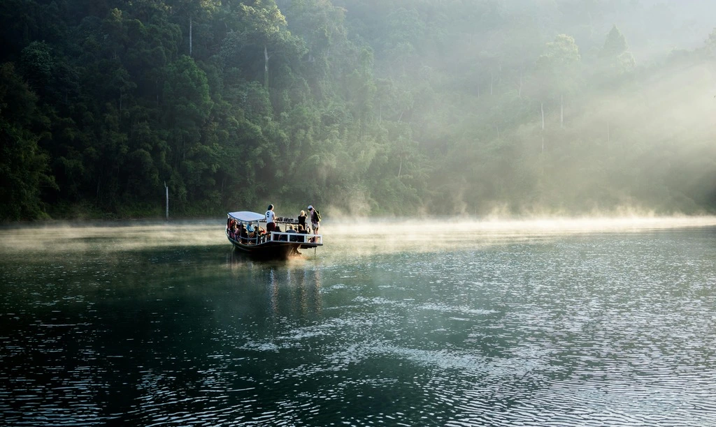 7-Day Thailand Family Trip: 2 Perfect Itinerary Ideas 9 Wooden boat on the sea with hilly landscape in the background.