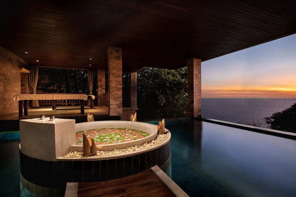 Whirlpool with rose petals sitting in infinity pool with seaview.