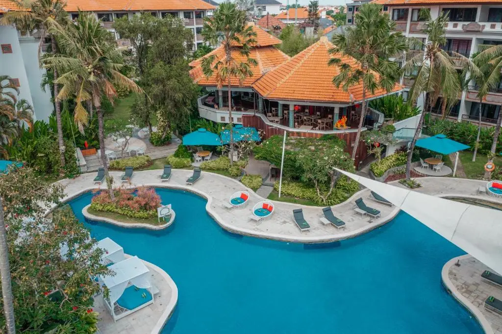 A swimming pool with lounge chairs and trees.