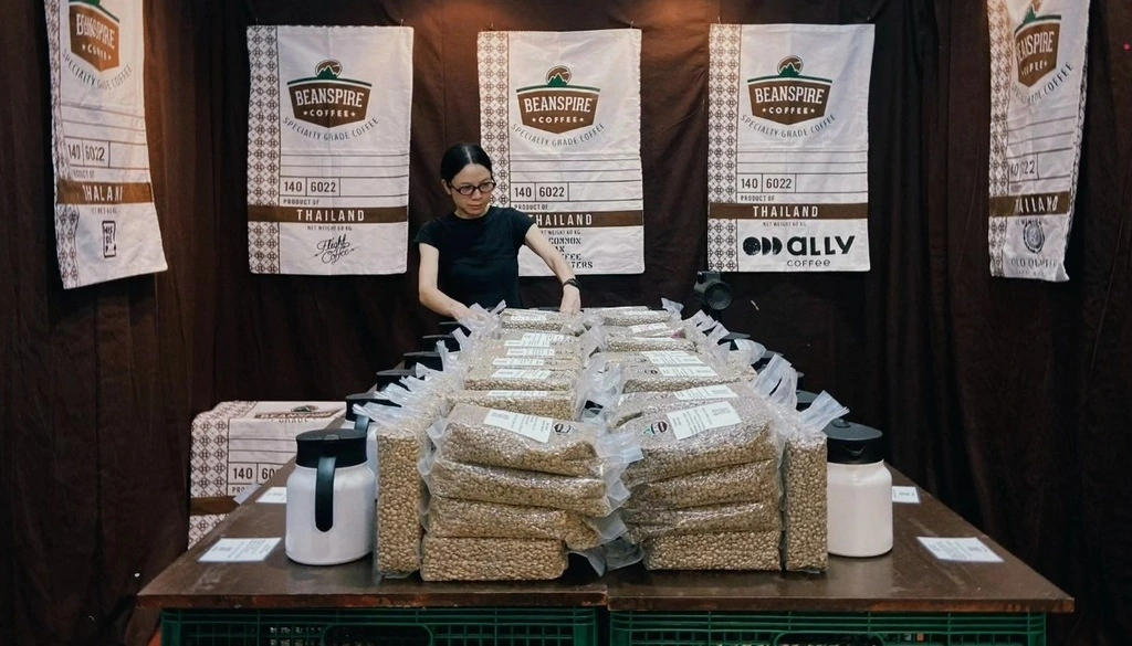 A woman standing behind a table with bags of beans.