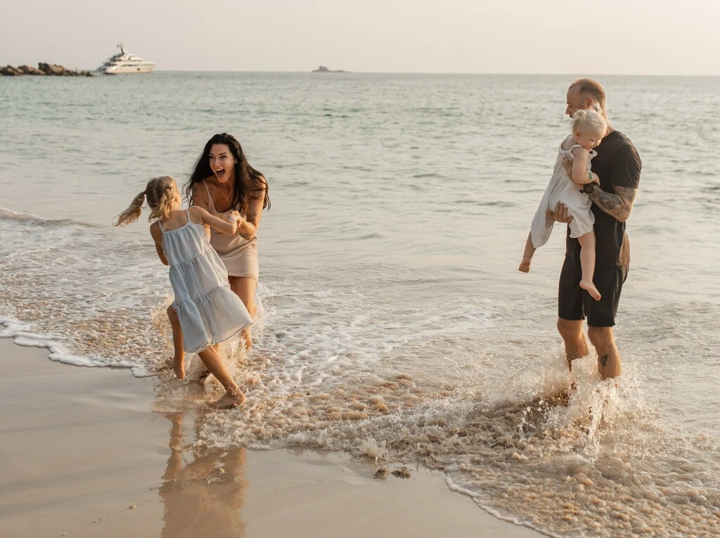 The Best Time to Visit Phuket: Weather, Season & Climate 1 A family of four playing on a beach.