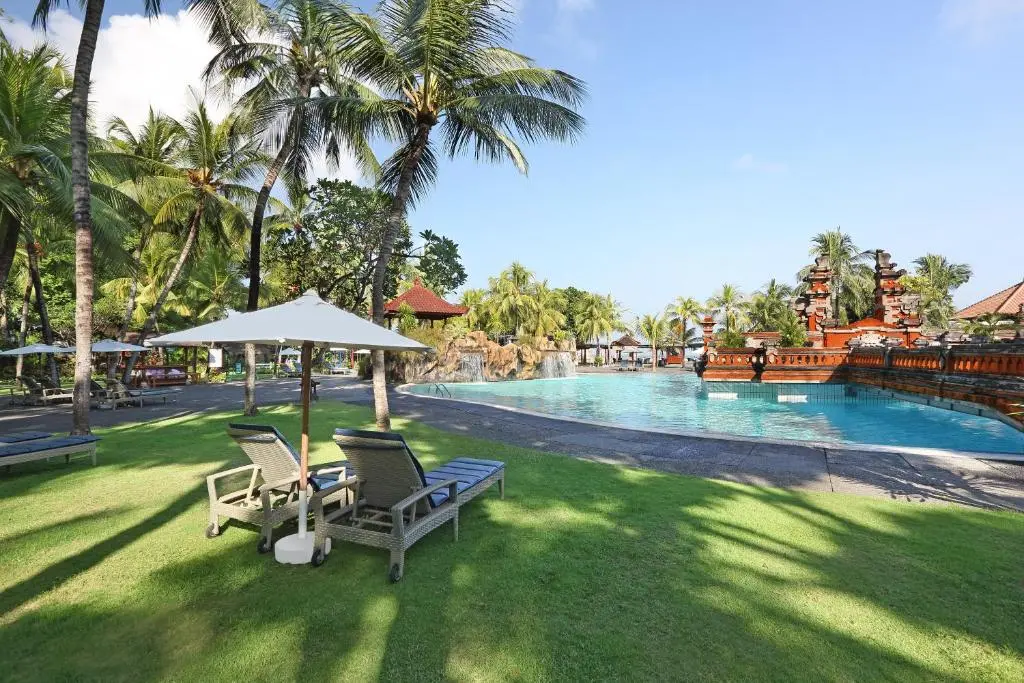 A pool with a couple chairs and umbrellas.