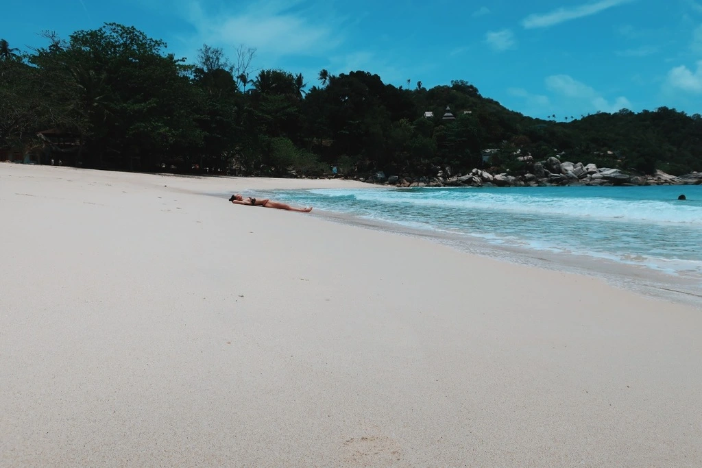 Guide to the Best Koh Phangan Beaches in 2025 6 A person lying on a large, white sandy beach.
