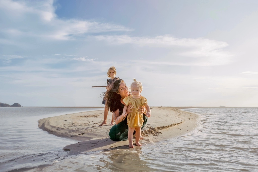 Guide to the Best Koh Phangan Beaches in 2025 5 A woman and two children on a beach.
