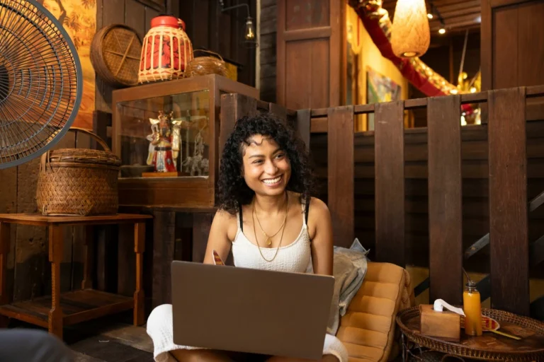 A woman sitting on a chair with a laptop.