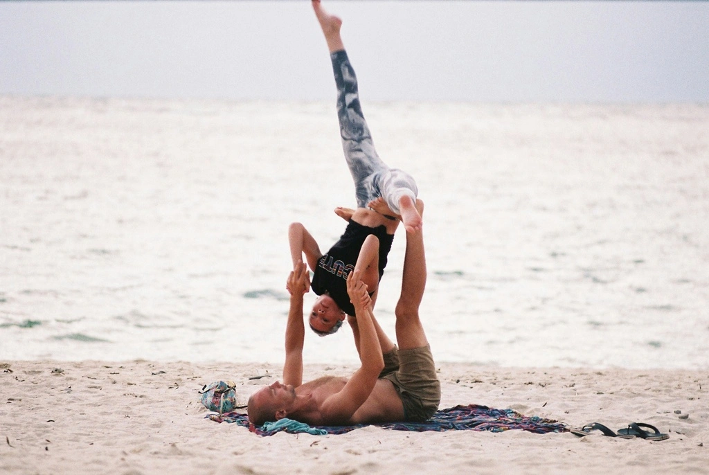 Guide to the Best Koh Phangan Beaches in 2025 11 A man and woman doing a acrobatic on a beach.