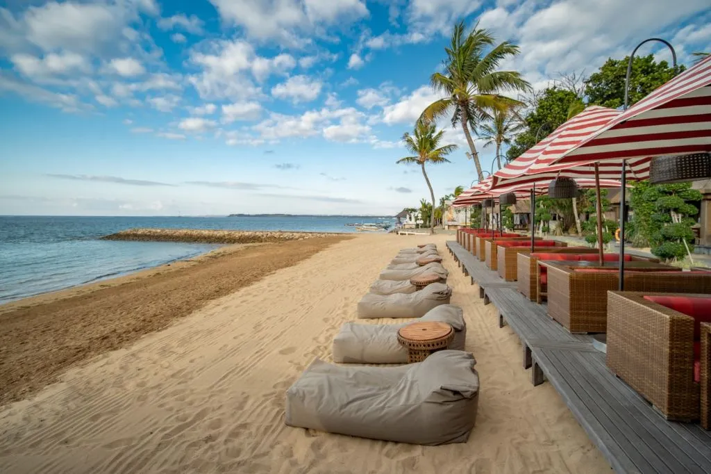 A beach with grey chairs and umbrellas.