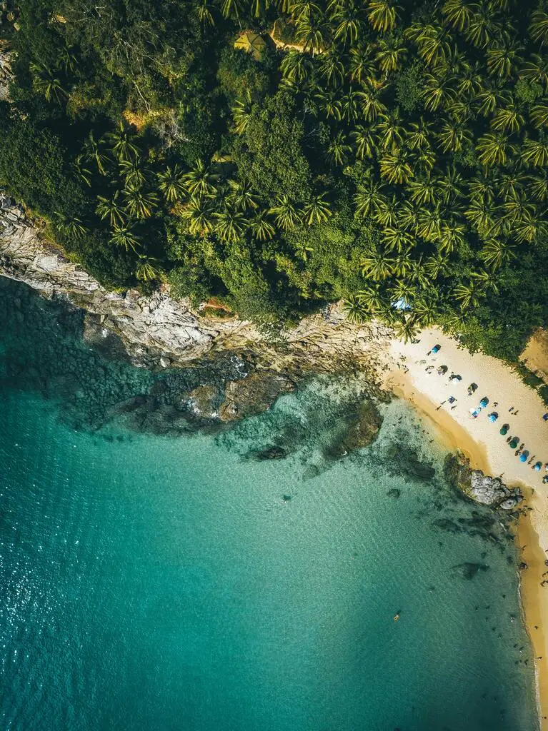 The Best Time to Visit Phuket: Weather, Season & Climate 2 An aerial view of a beach with trees and water.