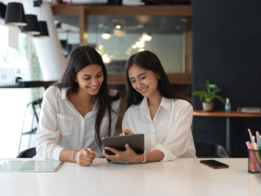 Two women looking at a tablet.