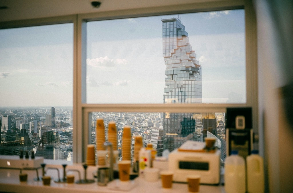 A window from a cafe with a view of a city with a skyscraper.