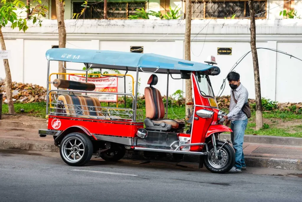 Ultimate 3-Day Chiang Mai Itinerary for First Timers 14 A man standing next to a red and black vehicle.