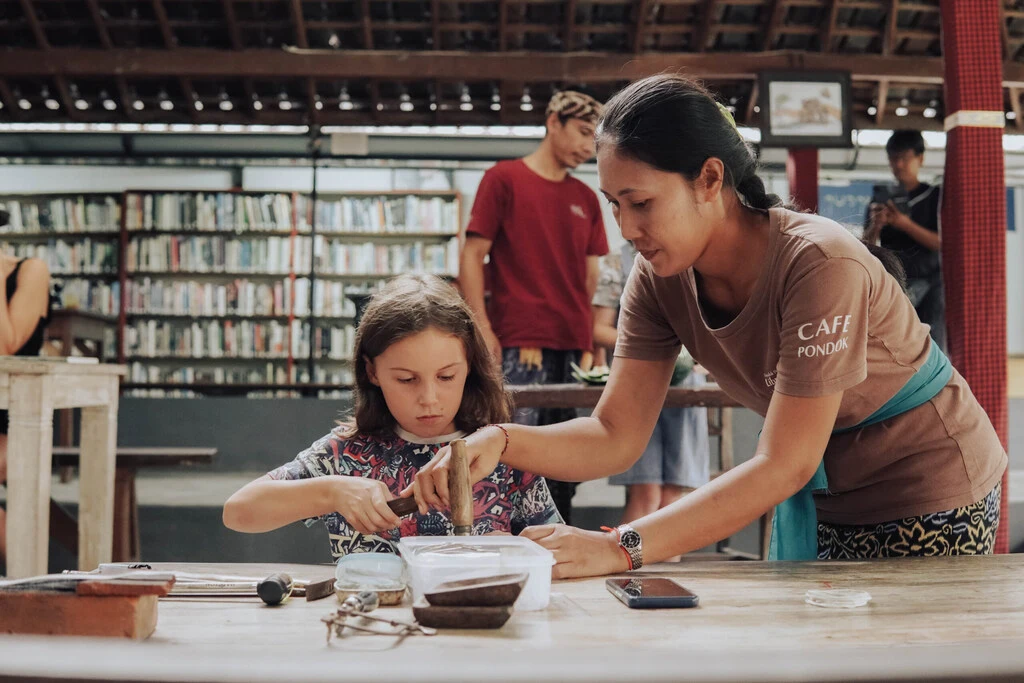 Bali Family Guide – Top 8 Things to do in Ubud with Kids 7 A woman and a girl using a hammer.