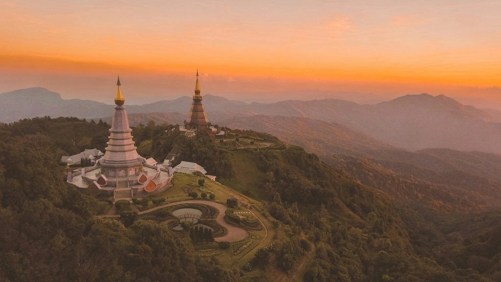 Two pagodas on a hill during sunset.