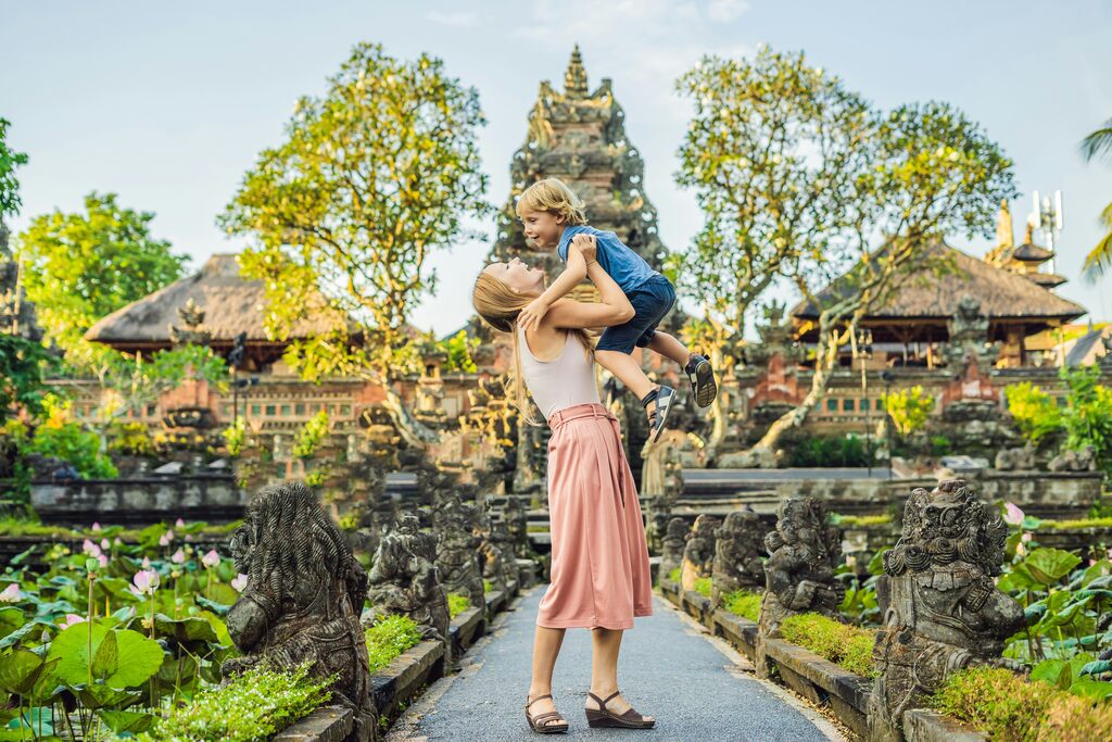 Mother holding her child in front of a balinese temple.