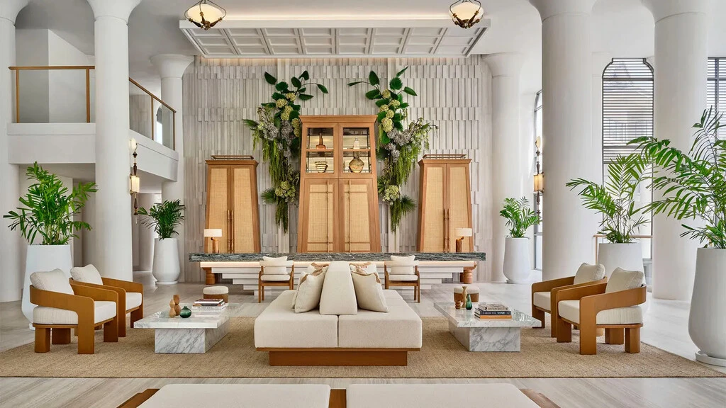 A room with a large white couch and a white wall.