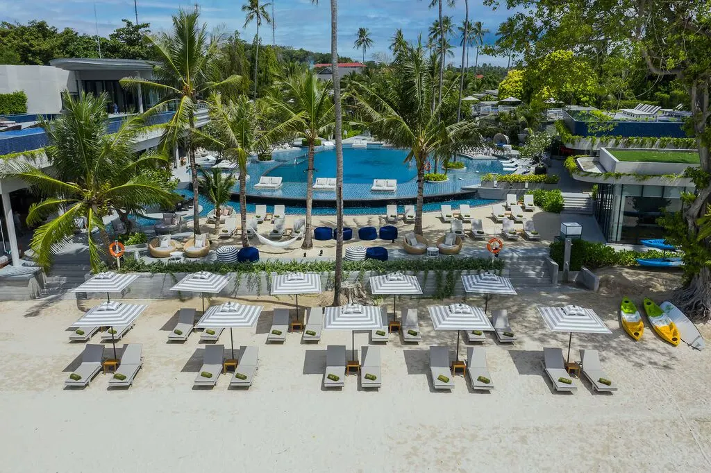 A pool with lounge chairs and umbrellas.