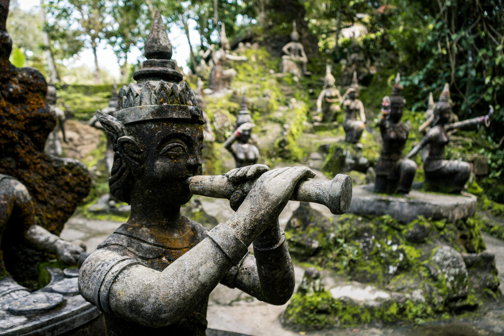 Koh Samui with Kids: 25 Super Fun Things to Do in 2025 6 A stone statue of a man playing a flute.