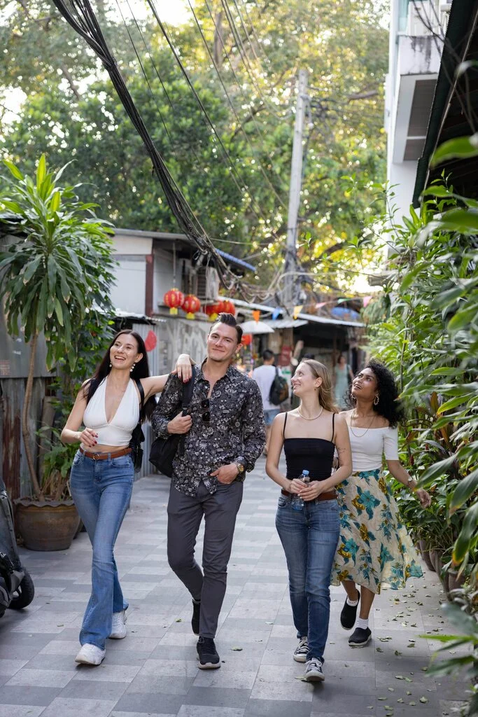 A group of people walking down a sidewalk.