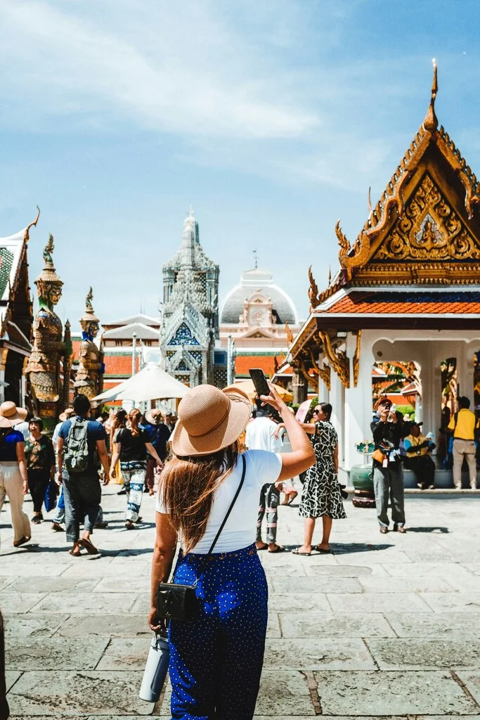 Thailand in December – Weather, Tips, and Top Spots 6 A woman taking a picture of a crowd of people.