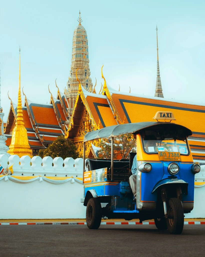 25 Fun & Interesting Thailand Facts Kids Will Love 12 A blue and yellow vehicle with a roof in front of a building. Thailand Facts Kids will love.
