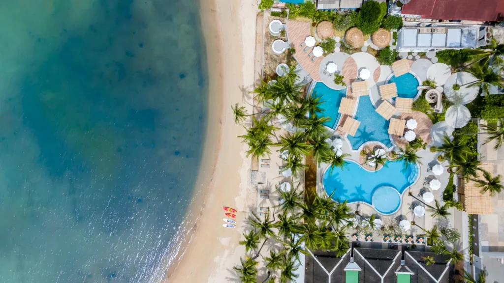 An aerial shot of a swimming pool and a beach.