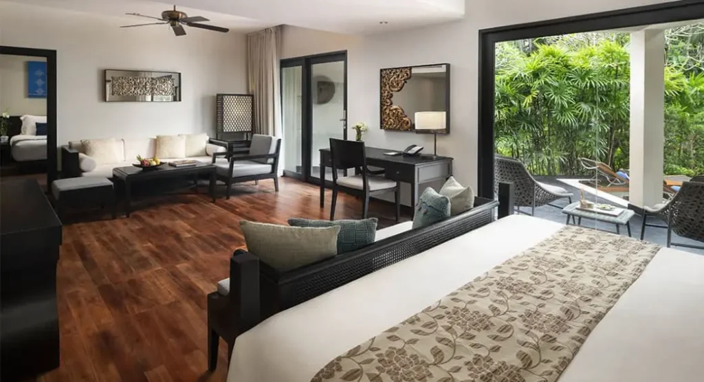 A room with a bed and a table and chairs.