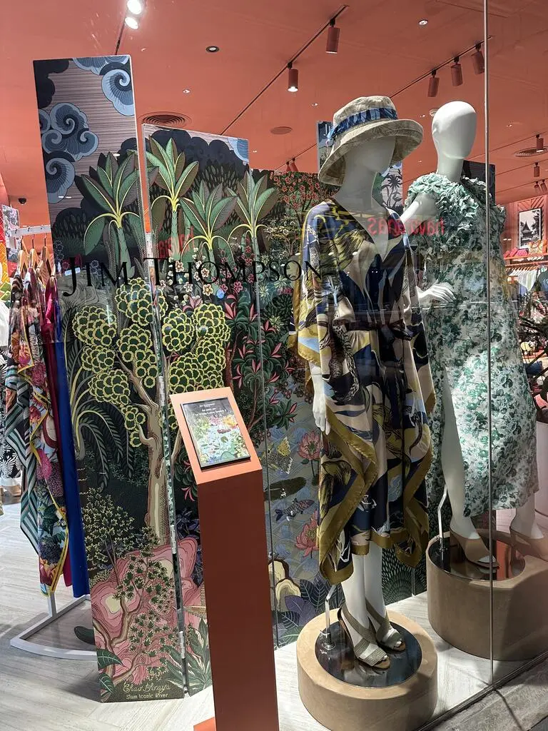 The window of a Jim Thompson Shop with colorful dresses.