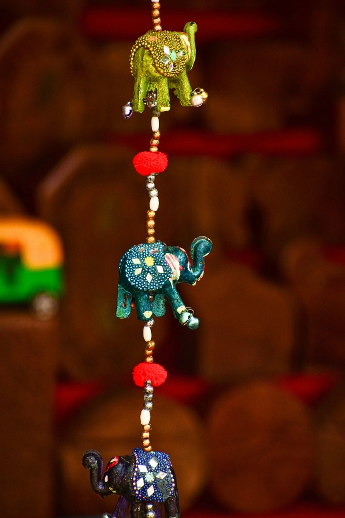 Elephant figurines hanging on a string.