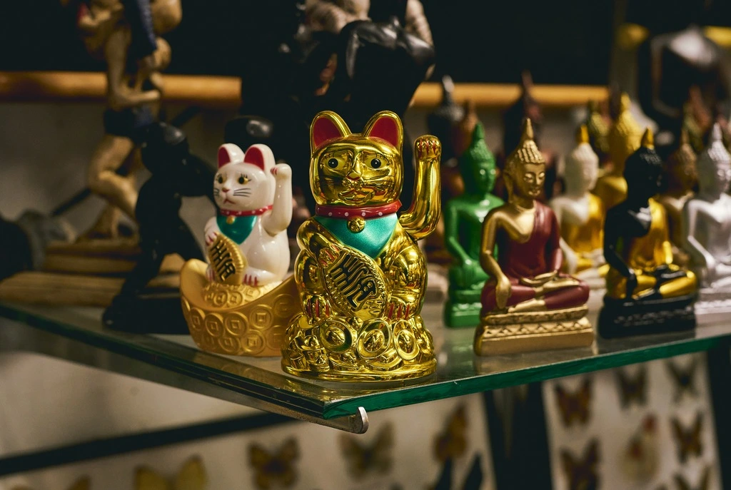 Big, golden cat figurine with waving paw.