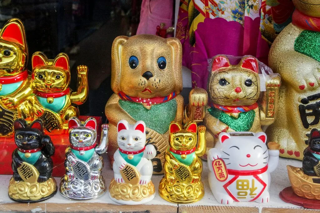 Multiple waving paw cat figurines.