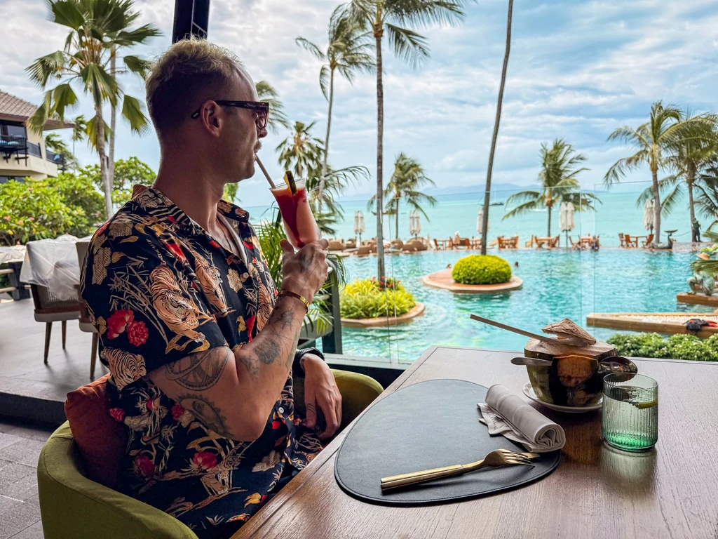 Anantara Bophut Koh Samui – Honest Family Review 2025 8 A man sitting at a table with a drink in his hand.