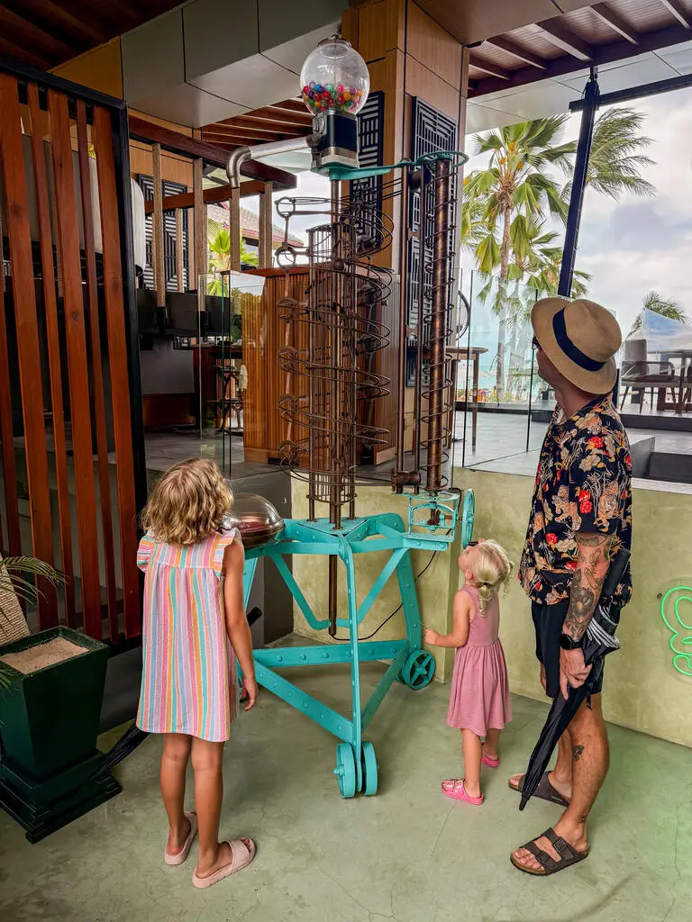 Anantara Bophut Koh Samui – Honest Family Review 2025 26 A man and two children looking at a spiral object.