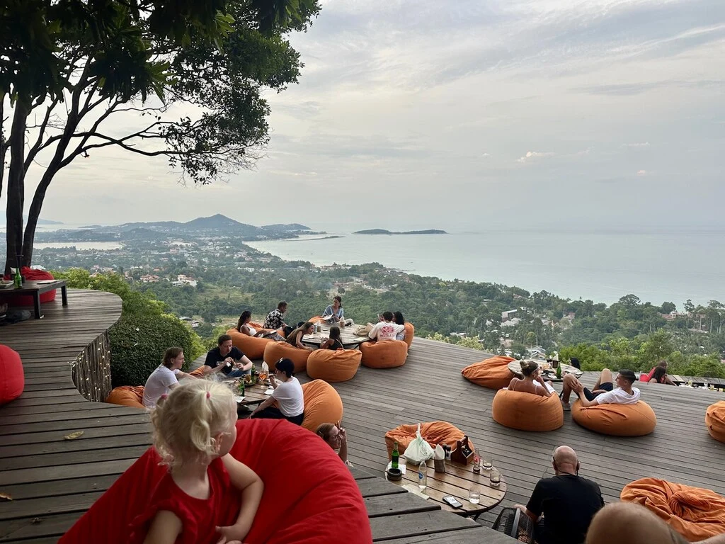 Koh Samui with Kids: 25 Super Fun Things to Do in 2025 24 A wooden platform with people sitting on red bean bags at The Jungle Club in Koh Samui.