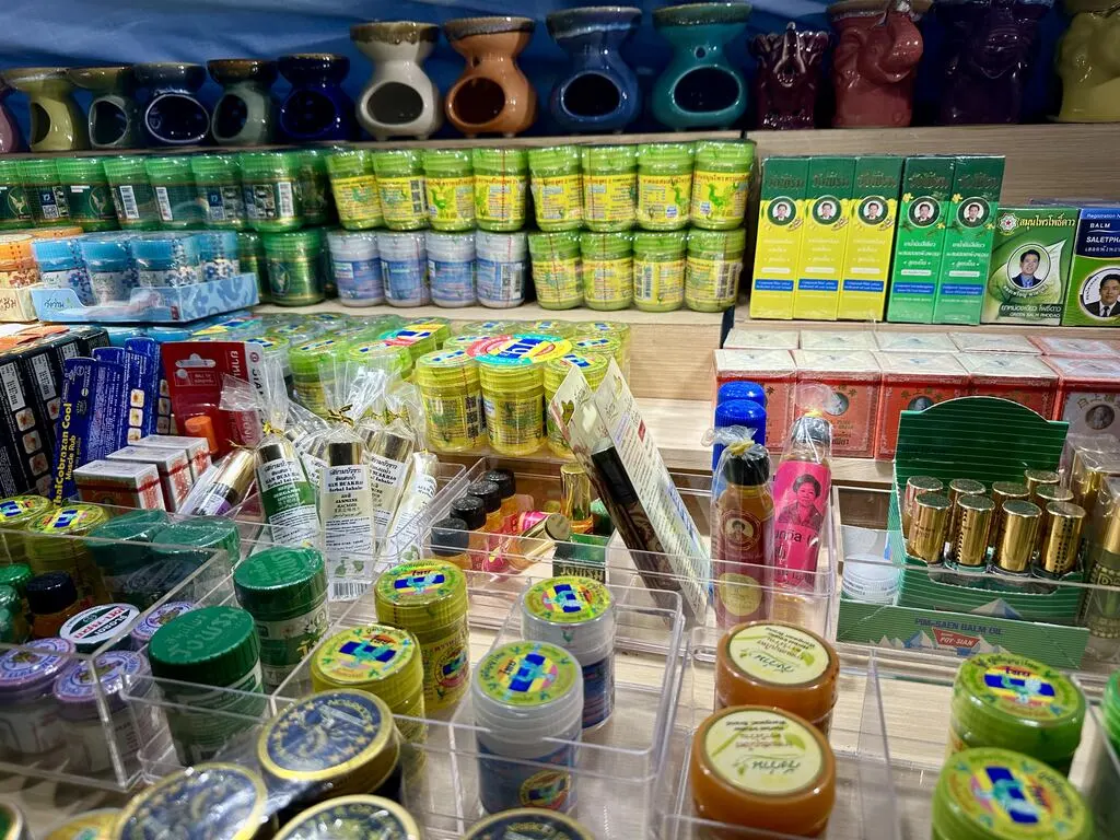 A stall with yellow and green thai inhalers and balms.