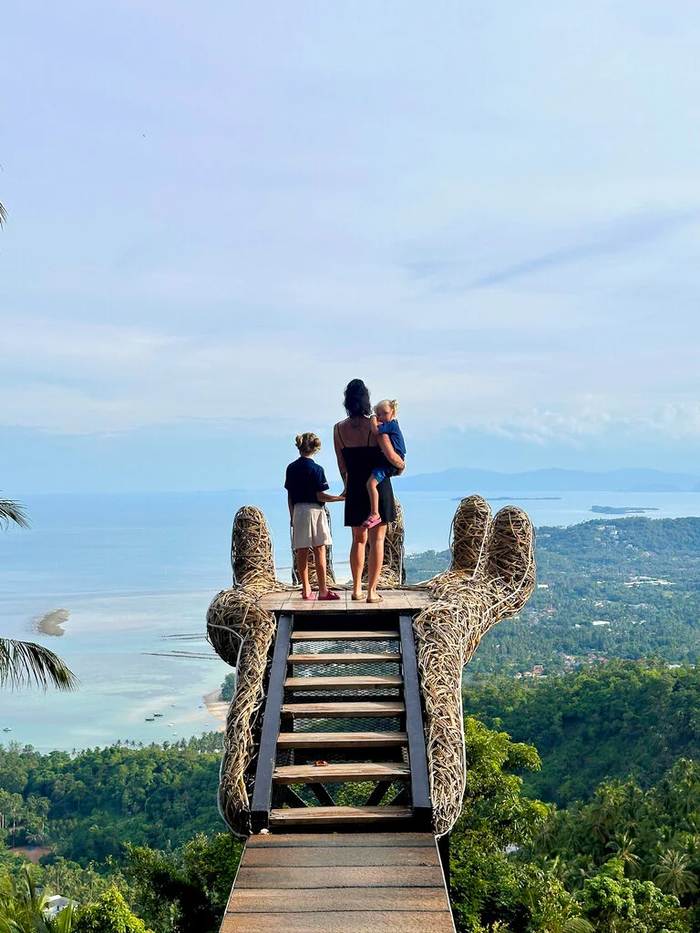 Koh Samui with Kids: 25 Super Fun Things to Do in 2025 16 A woman and two children standing on a wooden hand with a view of the ocean.