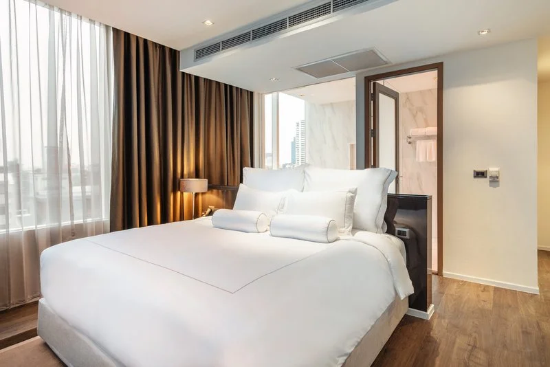 Rainy Season in Thailand – All You Need to Know 14 A bed with white sheets and pillows in a room.