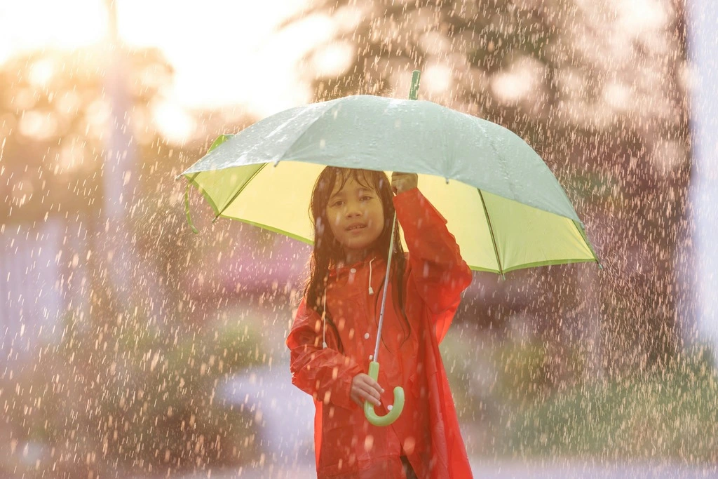 A girl holding an umbrella in the rain.