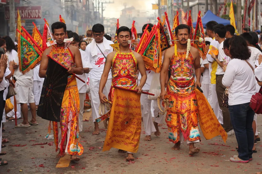 A group of men in colorful clothing walking down a street.