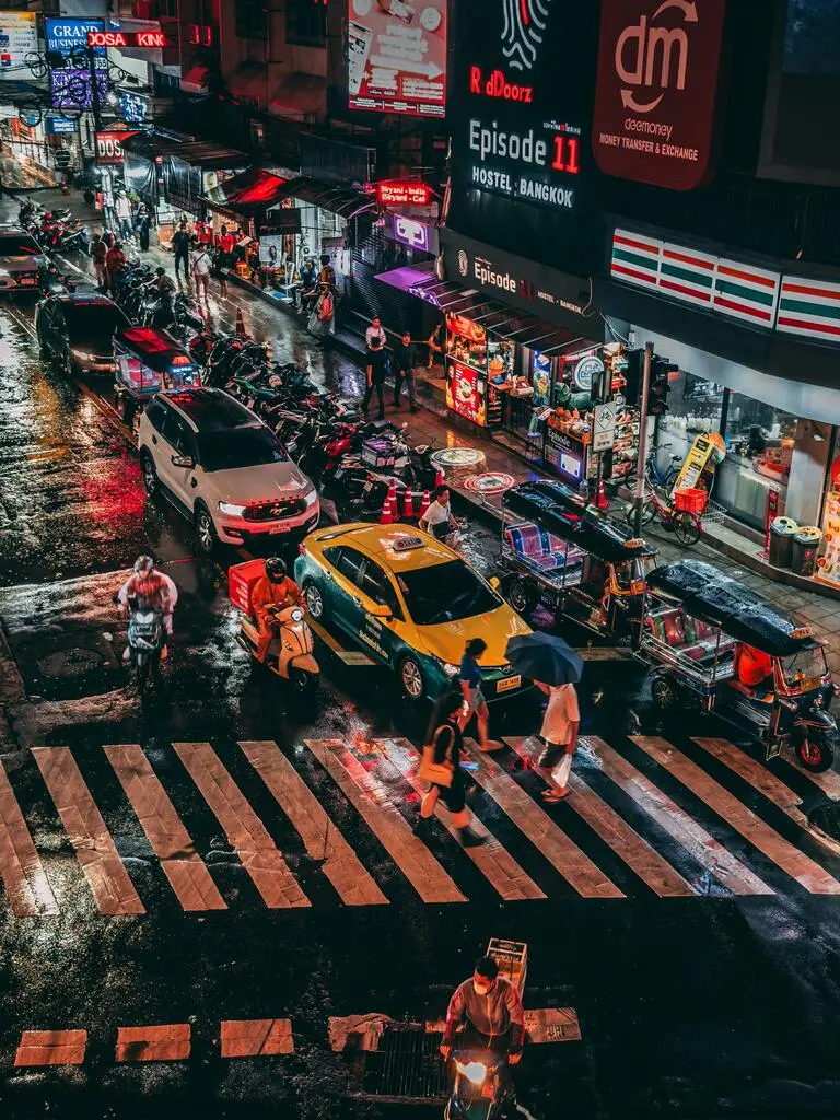 A street with cars and people on it.
