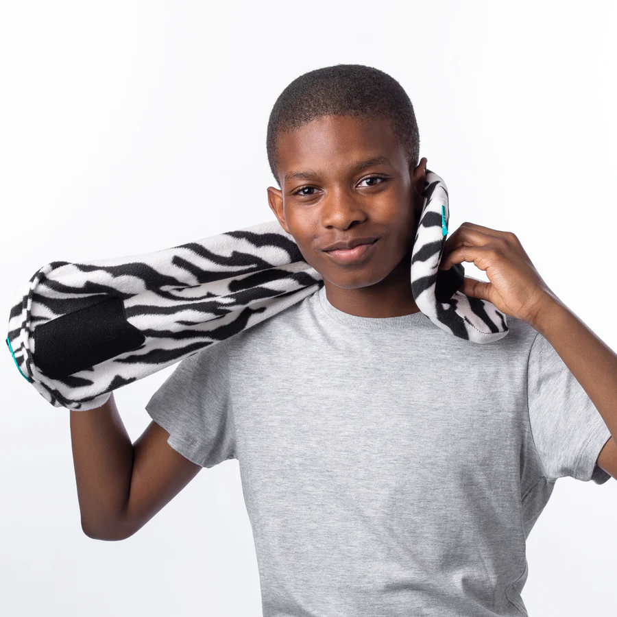 The 5 Best Travel Pillows for Kids in 2025 22 A boy holding a zebra print pillow over his shoulder.