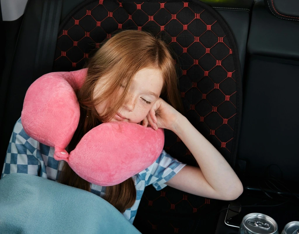 A girl sleeping with a pillow on her neck.