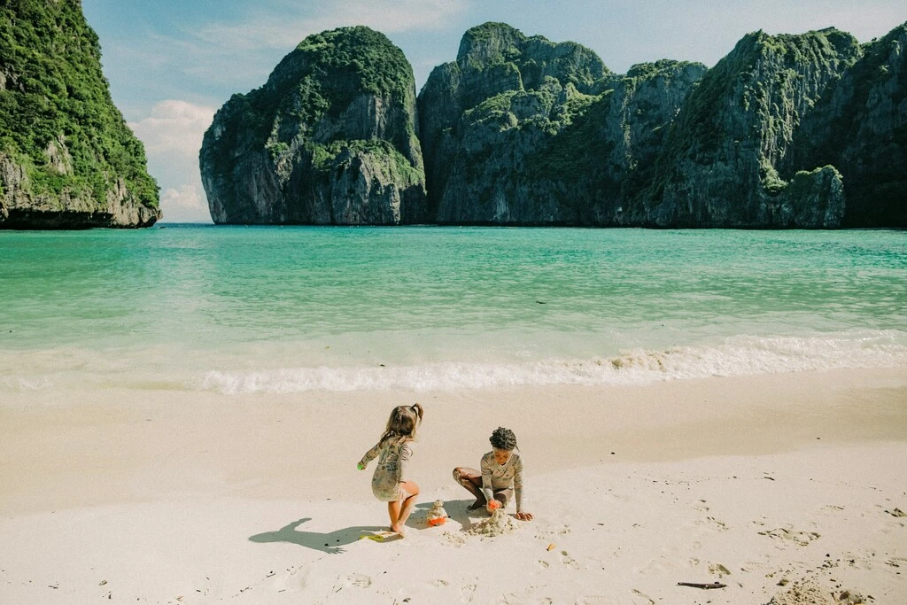Two kids playing on a beach in Thailand in December.