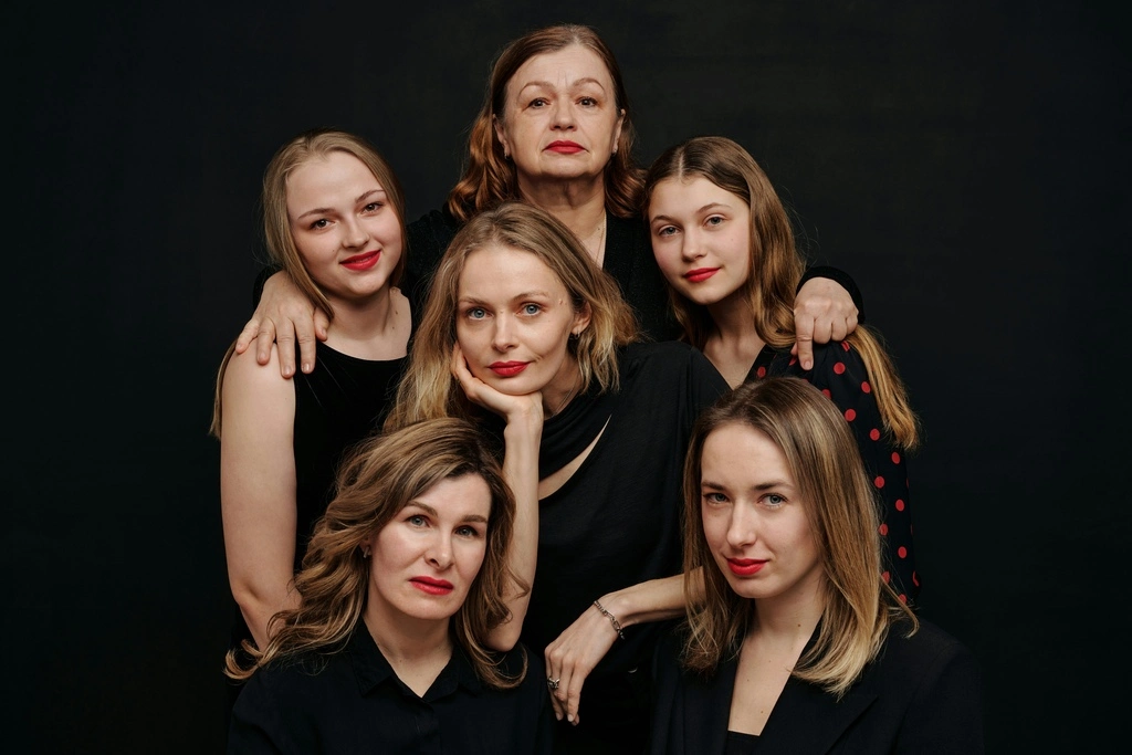 Family posing in a black studio room.