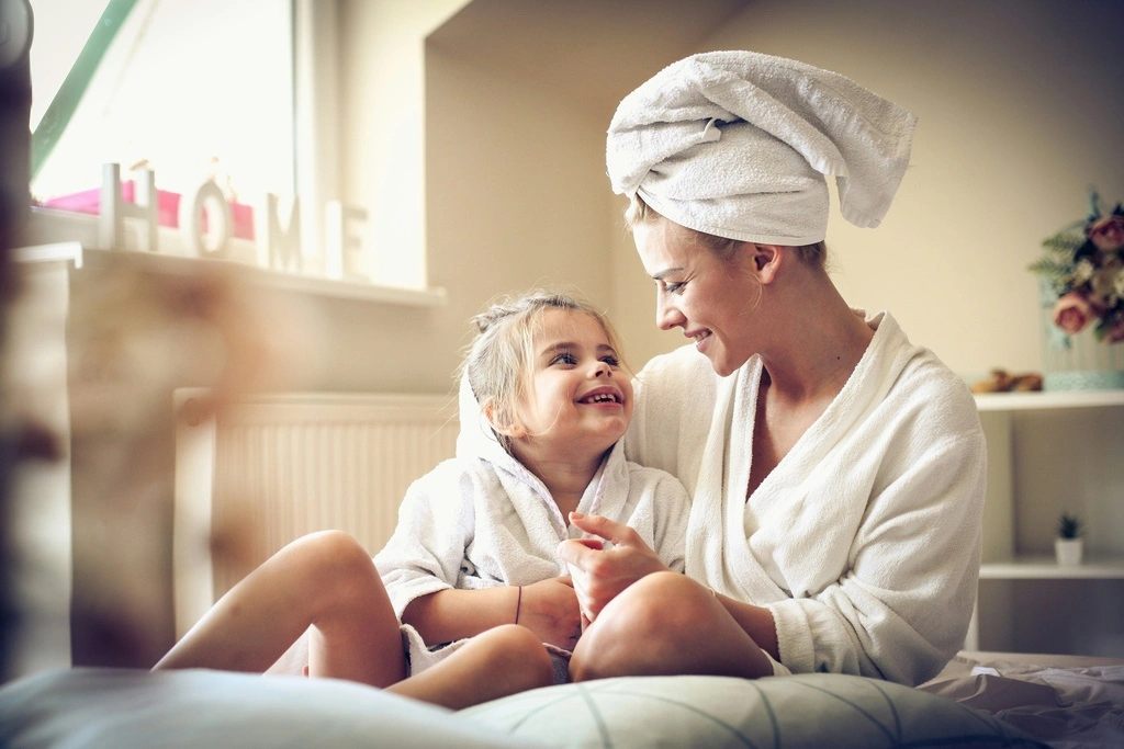Mother and daughter sitting on a sofa together.