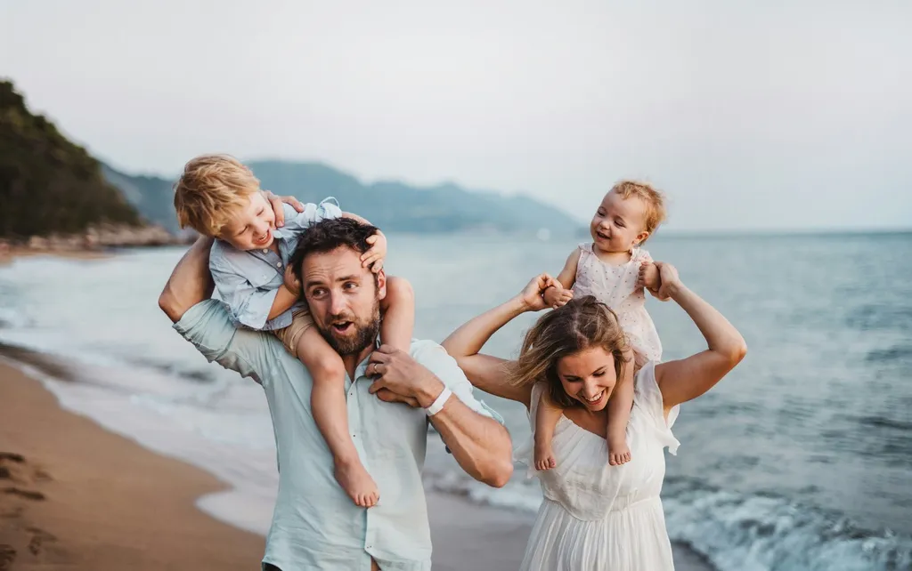 Family of four walking on a beach.