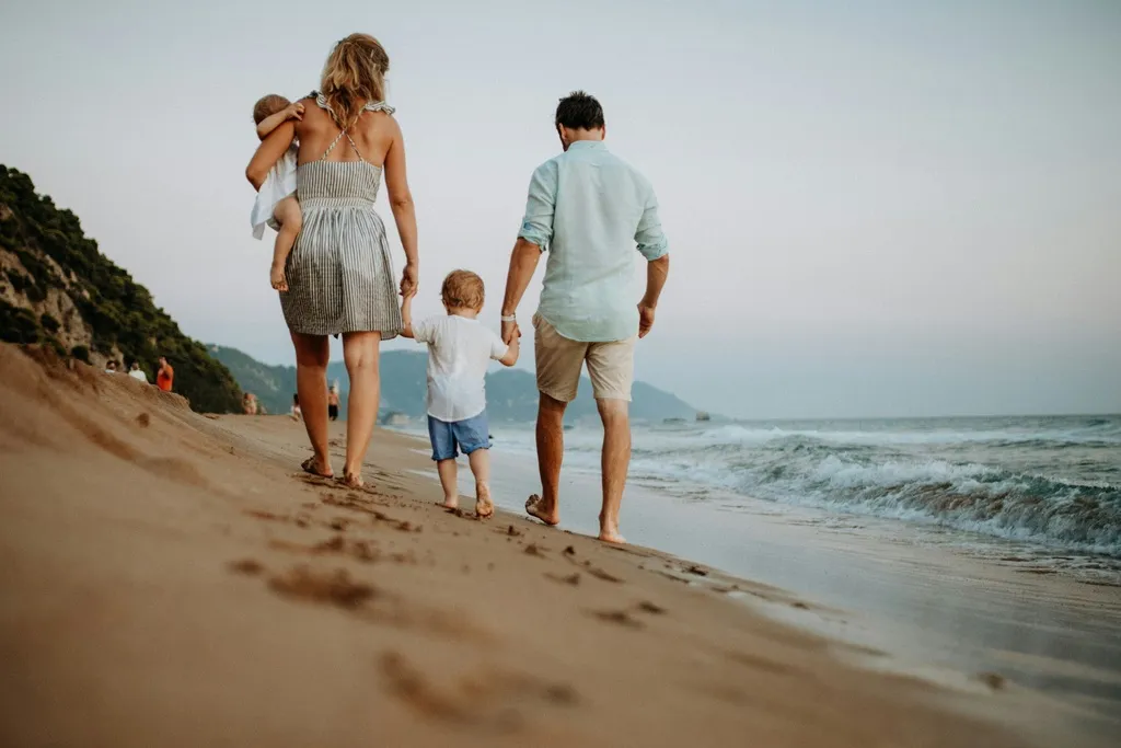 Family of four walking on the beach.