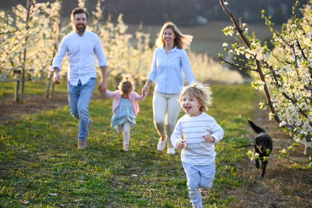 Family running on gras field. Family Photoshoot Ideas.