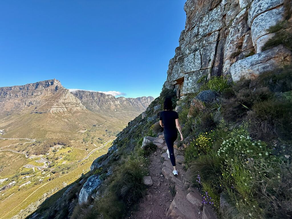 Hiker on rocky trail, scenic mountains, the Lion's head hike in Cape Town.