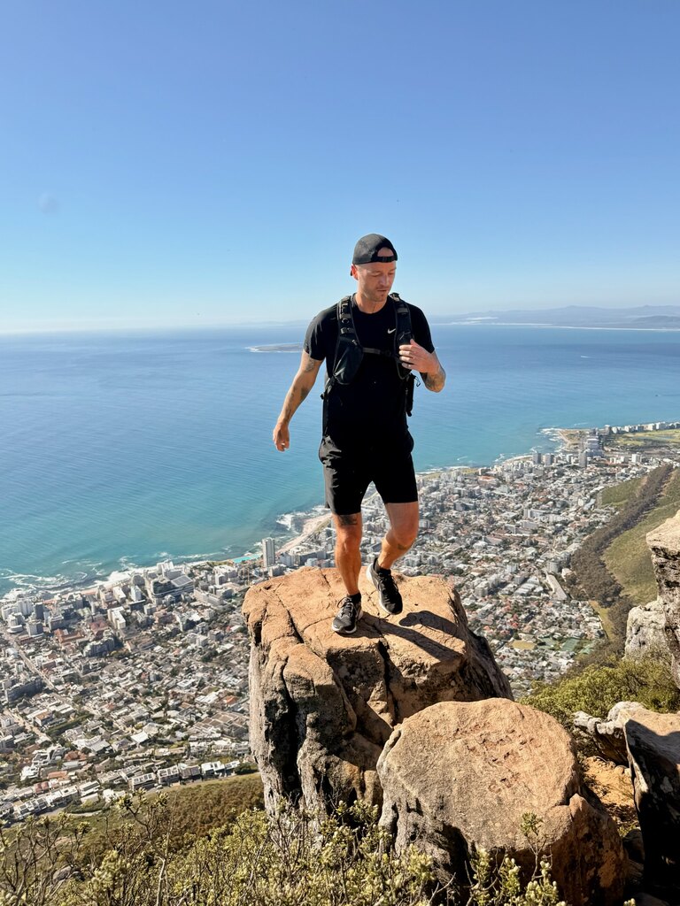 Hiker standing on rocky cliff edge.