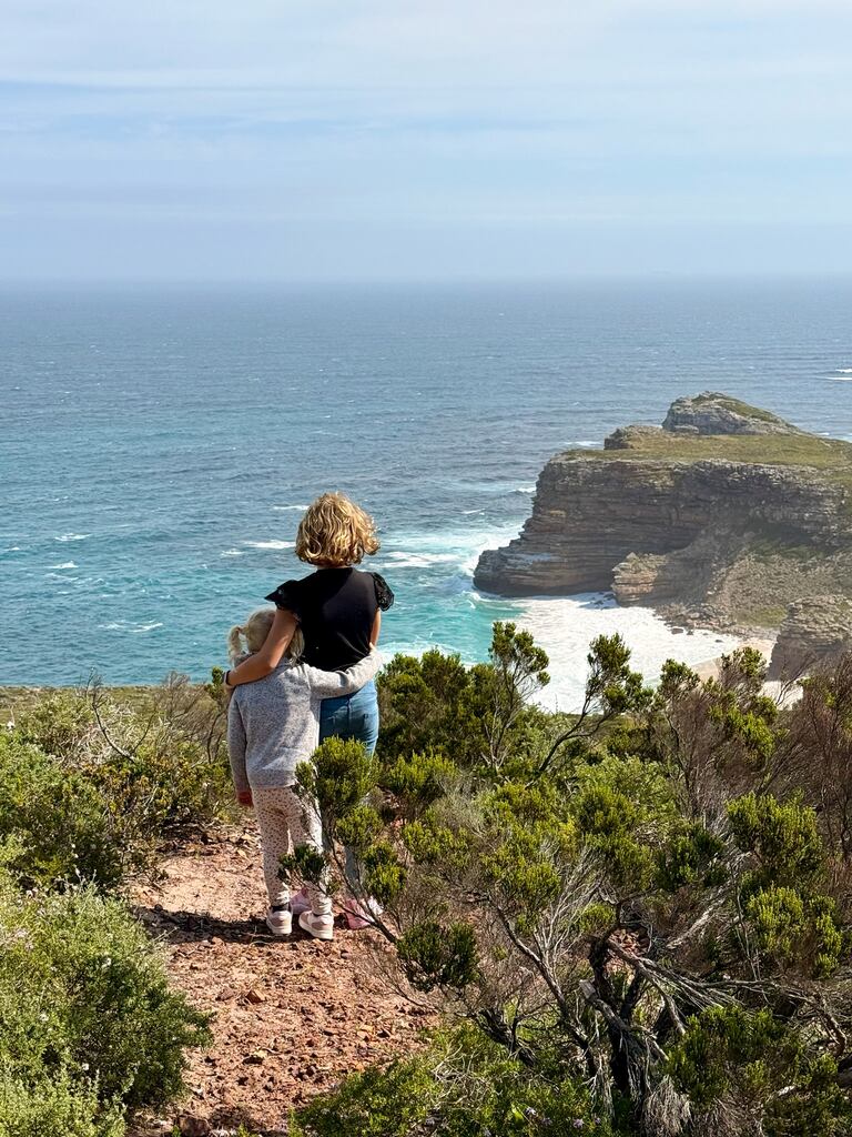 Two children overlooking ocean cliffs.